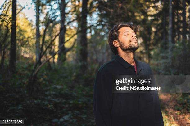 portrait of man enjoying the sunny day in the forest - zen like stock pictures, royalty-free photos & images