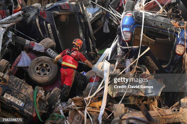 Members of the fire brigade, which are part of a search and rescue unit, carry out work as cars and debris block a tunnel on the border of Benetusser...