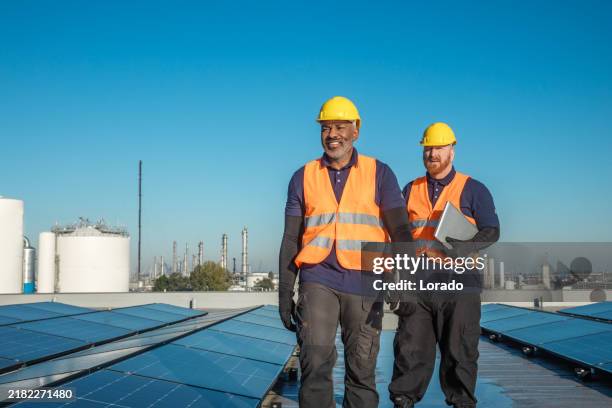two solar panel engineers on a sunny day - black roof stock pictures, royalty-free photos & images