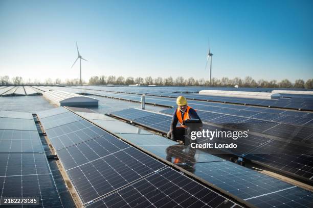 a black solar panel engineer on a sunny day - zonnepanelen stockfoto's en -beelden