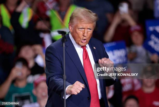 Former US President and Republican presidential candidate Donald Trump dances as he arrives to speak during his final campaign rally at the Van Andel...
