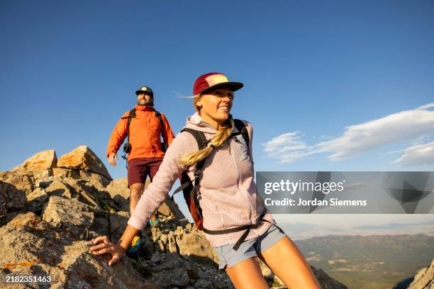 a couple enjoying a day hike in the scenic mountains of montana. - hiking stock pictures, royalty-free photos & images