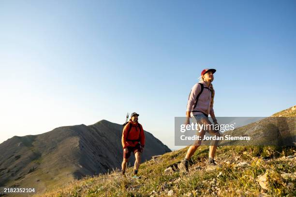 a couple enjoying a day hike in the scenic mountains of montana. - freizeitaktivität im freien stock-fotos und bilder