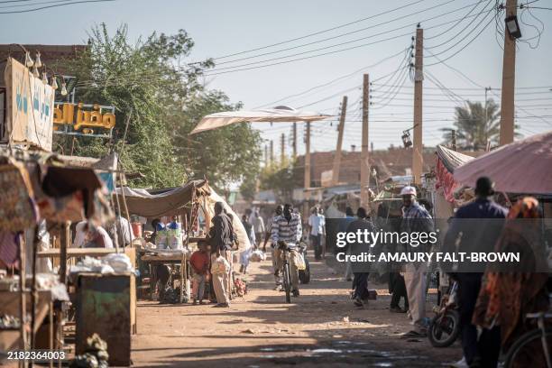 People make their way through a market area in Khartoum North on November 3, 2024. Sudan's war erupted in April 2023 between the regular army led by...