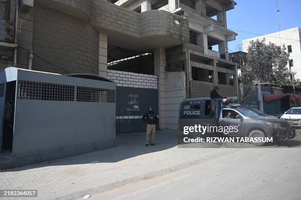 Pakistani policemen stand guard outside a factory where two Chinese nationals were reportedly shot by a security guard, in Karachi on November 5,...