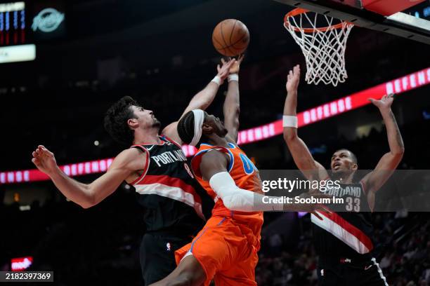 Shai Gilgeous-Alexander of the Oklahoma City Thunder shoots under pressure from Deni Avdija of the Portland Trail Blazers during the first half at...