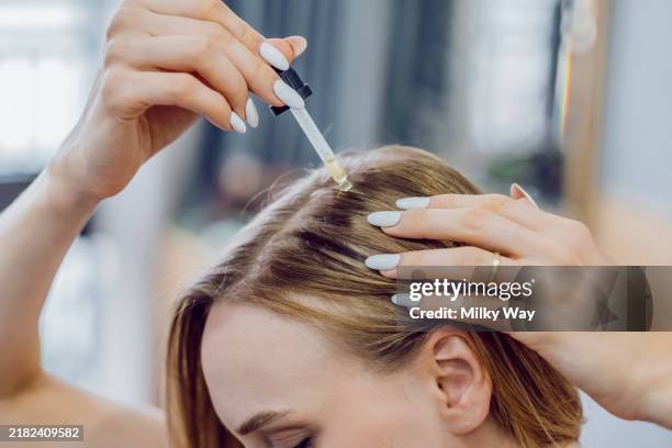 hair care routine with oil application for healthy scalp treatment. domestic beauty procedure. - cuero cabelludo fotografías e imágenes de stock