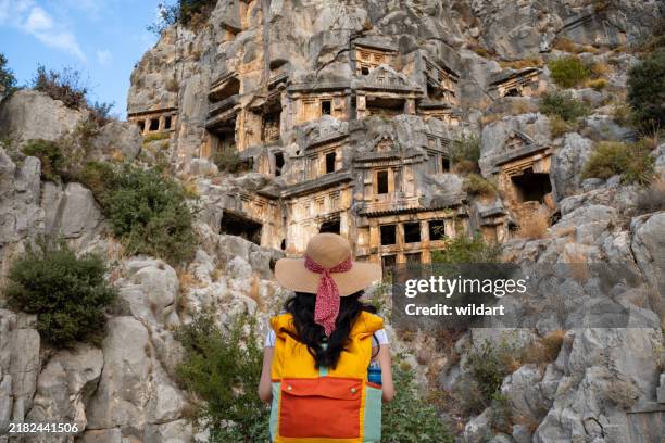 hermosa chica está observando las tumbas de roca licia de la antigua ciudad licia llamada myra ciudad antigua - arco característica arquitectónica fotografías e imágenes de stock