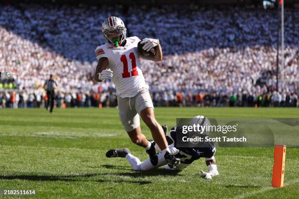 Brandon Inniss of the Ohio State Buckeyes catches a pass against Zion Tracy of the Penn State Nittany Lions for a touchdown during the second quarter...