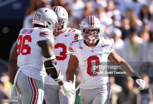 Cody Simon of the Ohio State Buckeyes celebrates with teammates after sacking Drew Allar of the Penn State Nittany Lions during the third quarter at...