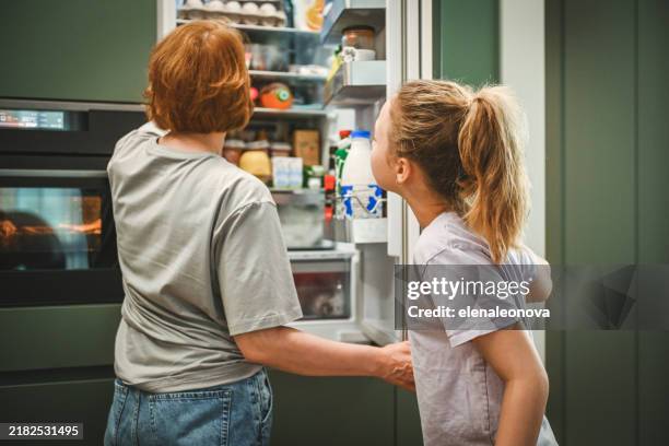 mutter und tochter kochen in der küche - kühlschrank stock-fotos und bilder