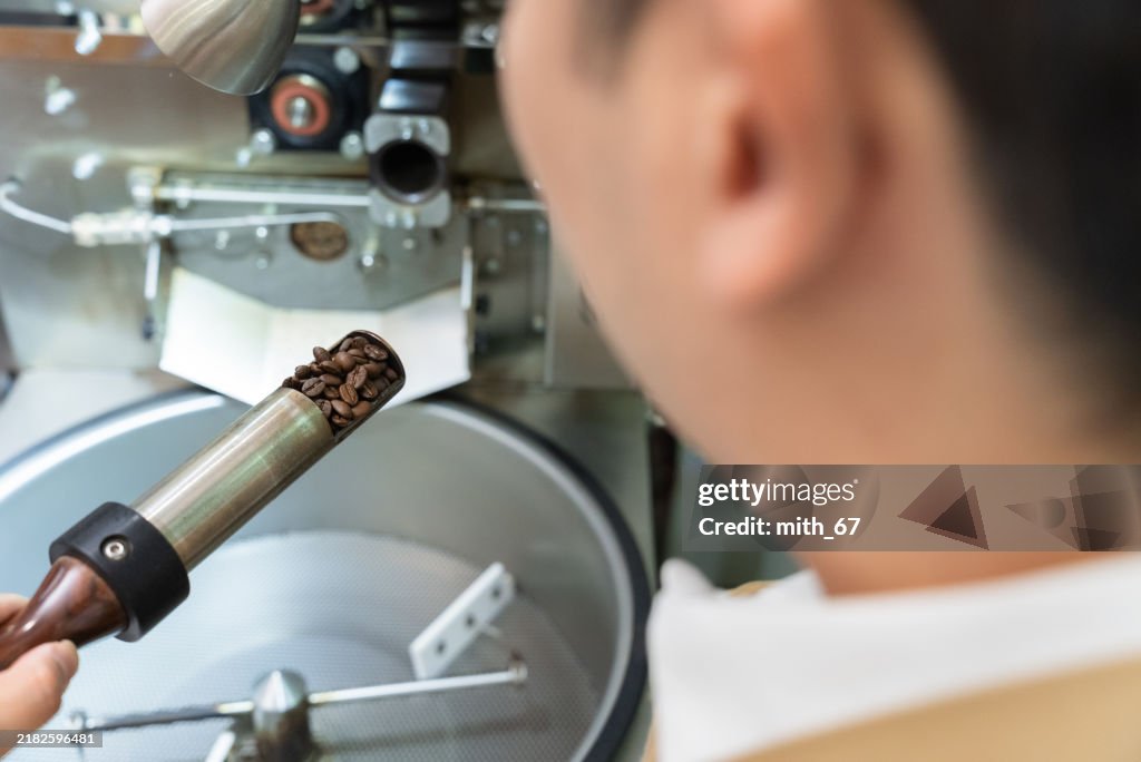 Asian Mid-Adult Man, Small Business Owner, Quality Checking of Roasted Coffee Beans with Sampling Spoon