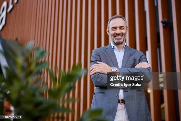 homme d’affaires confiant debout avec les bras croisés à l’extérieur - costume complet photos et images de collection