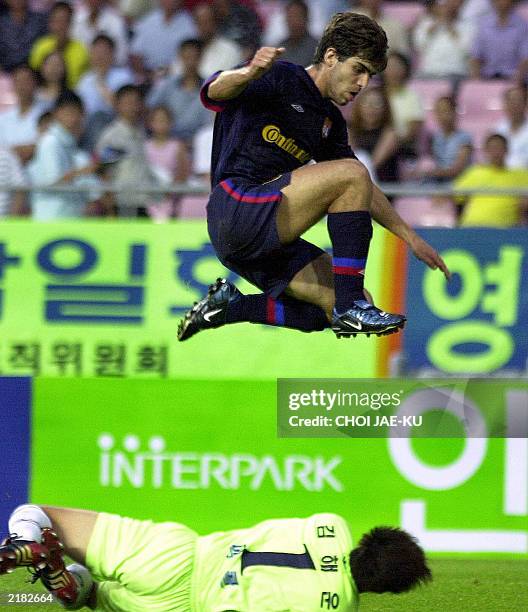 French soccer team Olympique Lyonnais's player Juninho Pernambucano jumps over South Korean team Seongnam Ilhwa's goalkeeper Kim Hae-woon during...