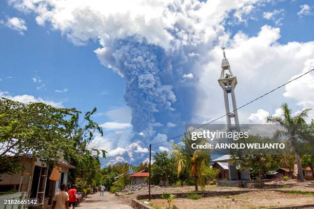 Schoolchildren run during the eruption of Mount Lewotobi Laki-Laki, as seen from Lewolaga village in East Flores, East Nusa Tenggara on November 7,...