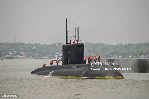 Crew members stand on the Russian Navy's UFA submarine as it prepares to dock at the North Jamrud pier of Tanjung Perak port for a 5-day joint...