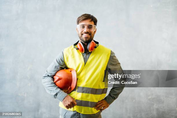 studio shot of construction engineer in protective uniform, wearing reflective vest and hardhat - construction worker isolated stock pictures, royalty-free photos & images
