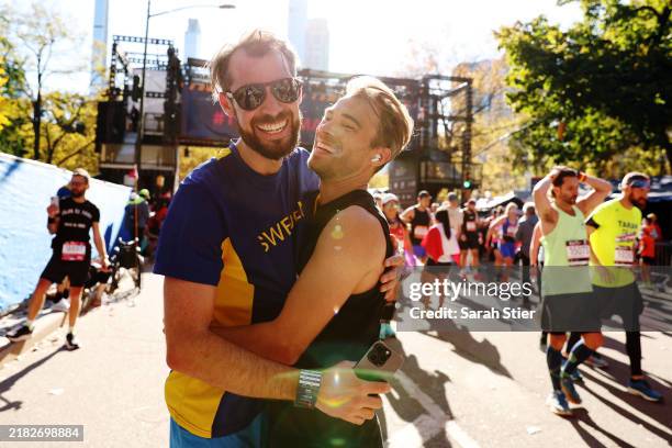 Runners react after crossing the finish line of the 2024 TCS New York City Marathon on November 03, 2024 in New York City.