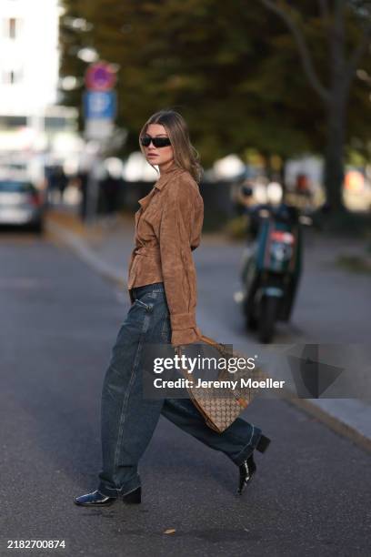 Sophia Geiss is seen wearing rectangular black sunglasses with a wide tapered temple from Prada; two different-sized gold hoop earrings and a gold...