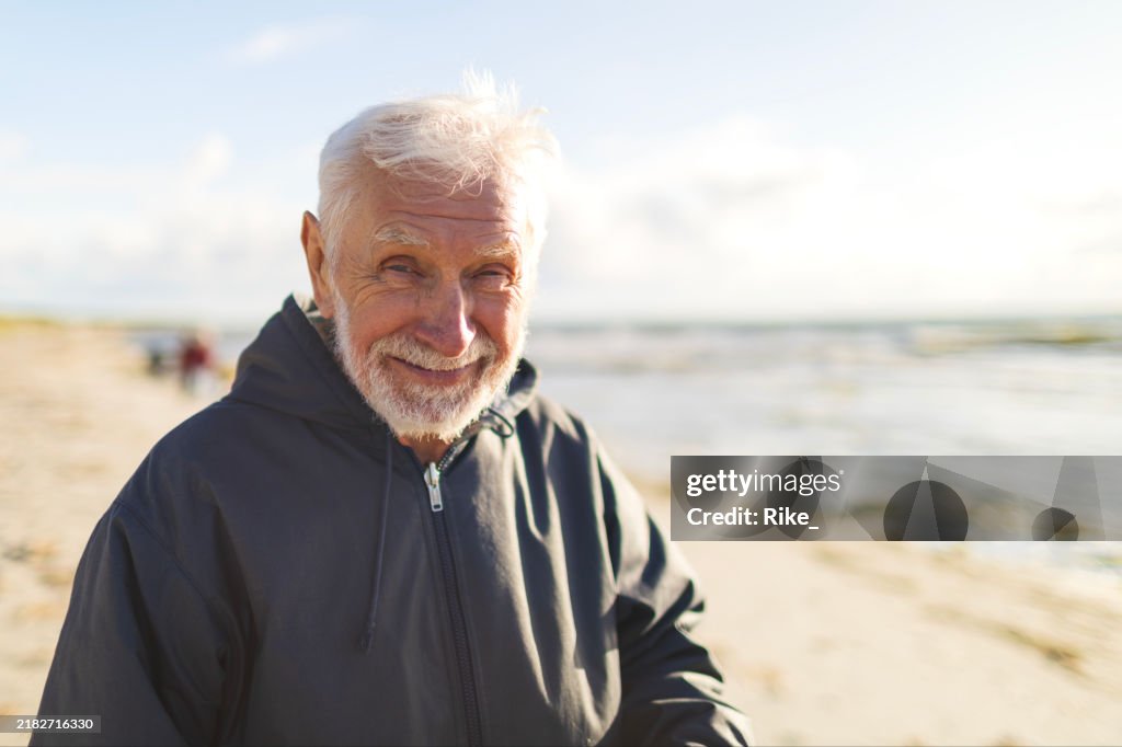 Friendly old man enjoys the sun at the Baltic Sea