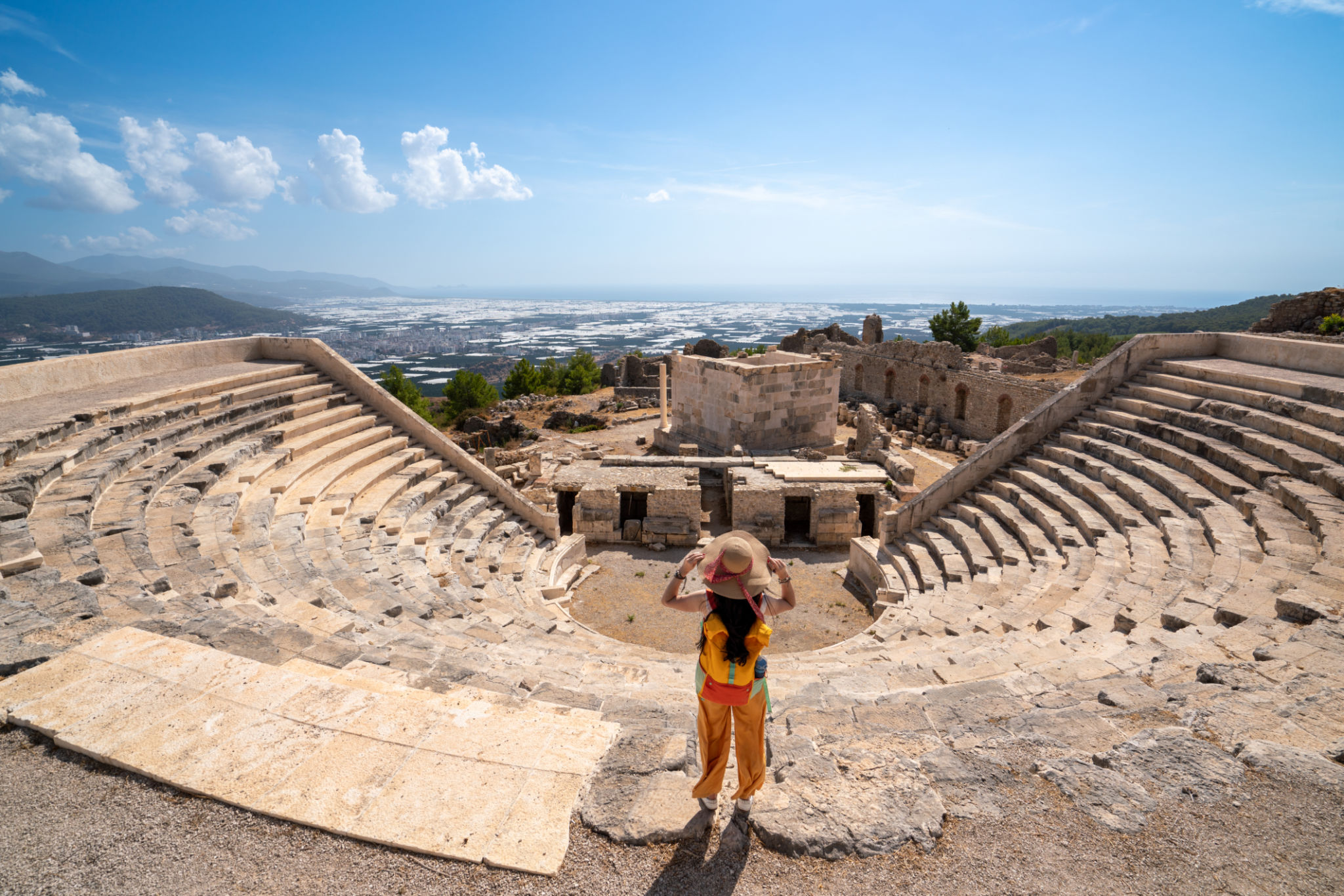 Beautiful girl is looking the scenery from the amphitheatre in ancient Lycian city called Rhodiapolis, also known as Rhodiopolis or Rhodia Beautiful girl is looking the scenery from the amphitheatre in ancient Lycian city called Rhodiapolis, also known as Rhodiopolis or Rhodia