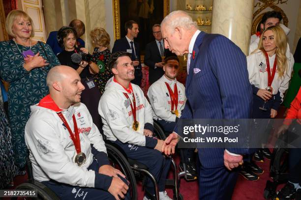 Britain's King Charles III speaks to tennis players Andrew Lapthorne Gordon Reid and Alfie Hewett during a reception for Team GB medallists from the...