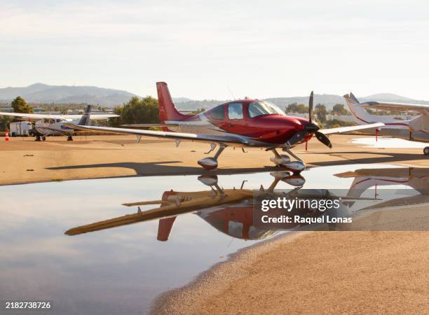small, red, private airplane with reflection - propeller stock-fotos und bilder