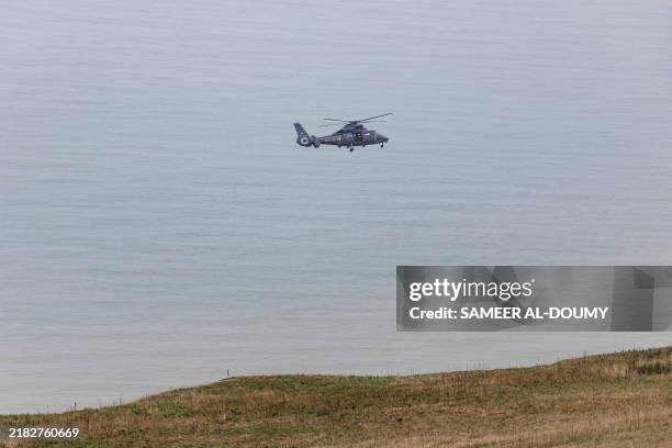 French Navy AS365 Dauphin flies to pick up an unconscious migrant at the foot of the cliffs of Cap Blanc-Nez, northern France where many migrants...