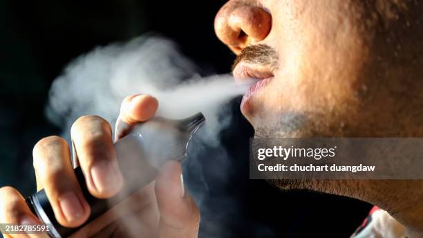 close-up of man using an electric cigarette - cigarette électronique photos et images de collection