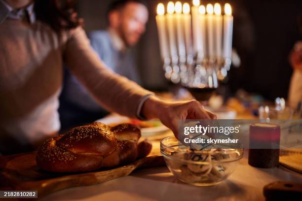 close up of a woman taking traditional cookies on hanukkah. - hanukkah stock pictures, royalty-free photos & images