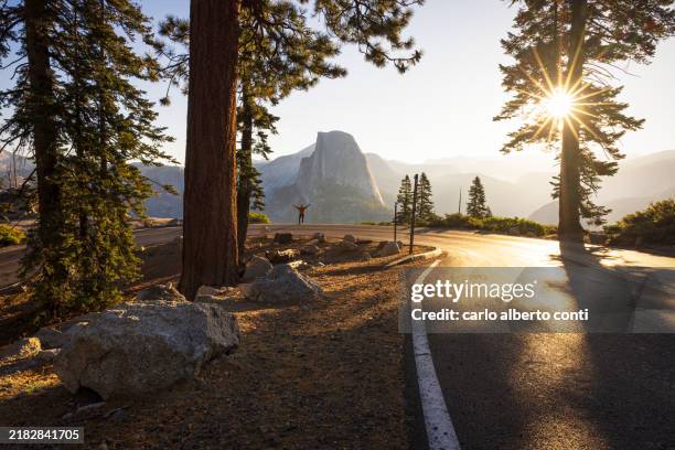 a man watches the sunrise in front of the iconic half dome mountain, yosemite national park, california, united states of america - half dome stock pictures, royalty-free photos & images