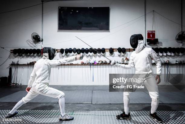 hombres practicando esgrima en un club de salud - tirador fotografías e imágenes de stock