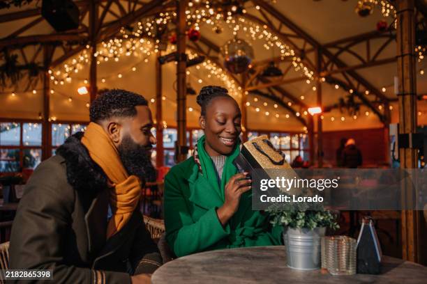a beautiful black couple at winter xmas shopping in the netherlands - festieve stemming stockfoto's en -beelden