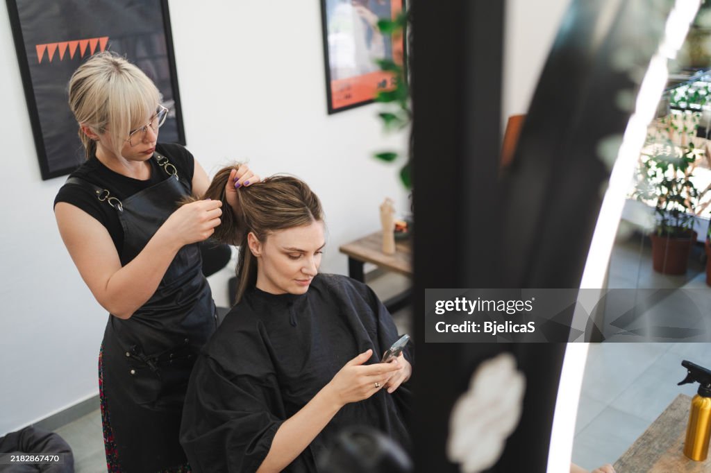 Client using phone in a salon