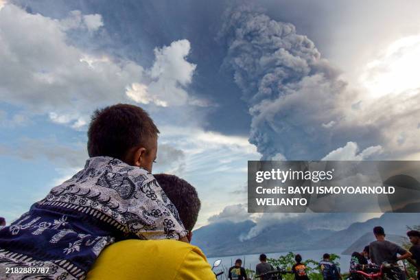 Residents watch the eruption of Mount Lewotobi Laki Laki from Eputobi village in Titihena, East Nusa Tenggara, on November 8, 2024.