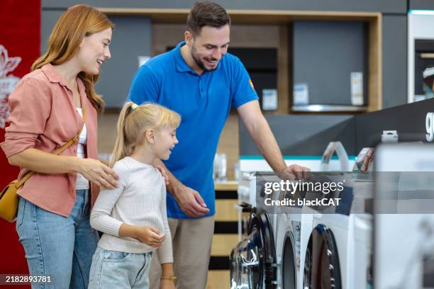 familie erkundet waschmaschinen in einem haushaltsgerätegeschäft - personal assistant device stock-fotos und bilder