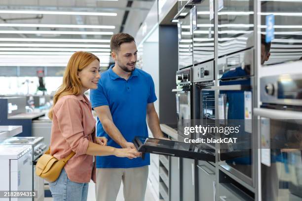 kundin, die küchengeräte in einem modernen geschäft kauft - haushaltsmaschine stock-fotos und bilder