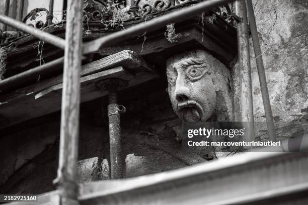 historic building under renovation with sculpted stone face - historic building stock pictures, royalty-free photos & images