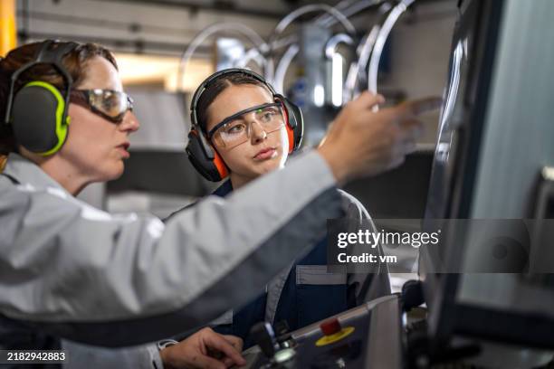 experienced cnc machine operator instructing trainee - internship program stock pictures, royalty-free photos & images