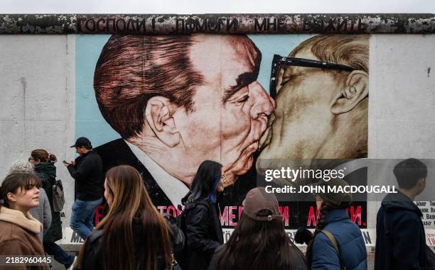 Tourists gather in front of the mural painting "My God, Help Me to Survive This Deadly Love" by Russian painter Dmitri Vrubel, depicting the kiss...