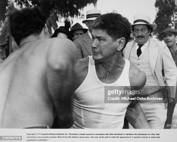 American actor Charles Bronson, wearing a white vest during a fight, with American actor Strother Martin, who wears a white suit and white hat, in...
