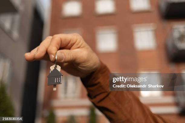 real estate agent holding house key close up. - renting stock pictures, royalty-free photos & images