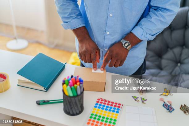 owner of an online shop owner young man labeling box. - labelling stock pictures, royalty-free photos & images