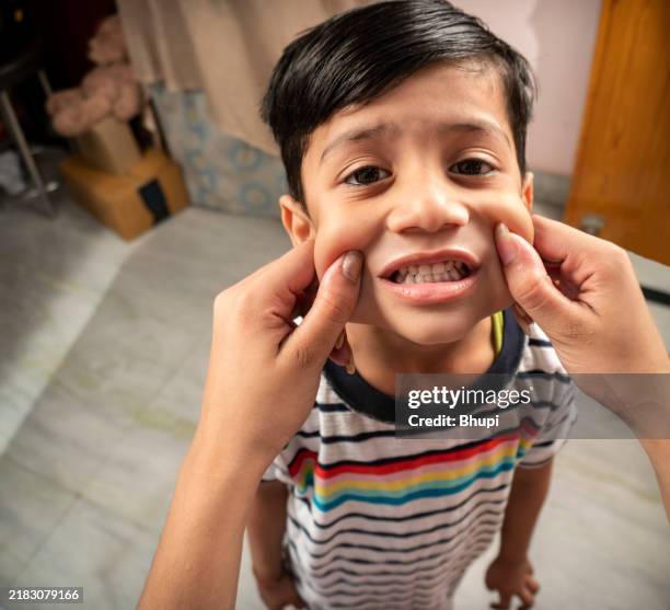 pov hand pulling cheeks of little boy. - cheek pinching stock pictures, royalty-free photos & images