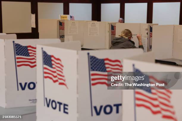 Student ponders her ballot in the polling site at Davies Student Center on Election Day, Nov. 5, 2024 at the University of Wisconsin-Eau Claire in...