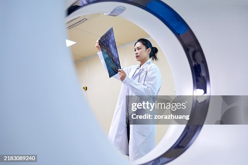 Female Doctor Checking Film at MRI-scanner Room Female Doctor Checking Film at MRI-scanner Room