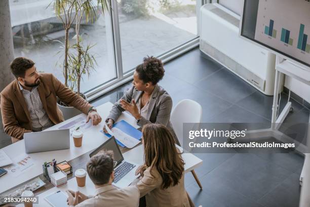 business professionals collaborate on project during meeting in modern office - risco imagens e fotografias de stock
