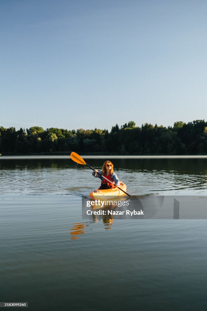 Alone woman kayaking on the lake