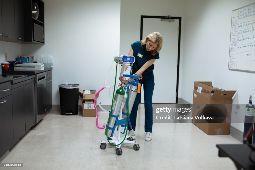 Female healthcare professional preparing a nitrous oxide delivery system for fast-acting pain relief and patient comfort.