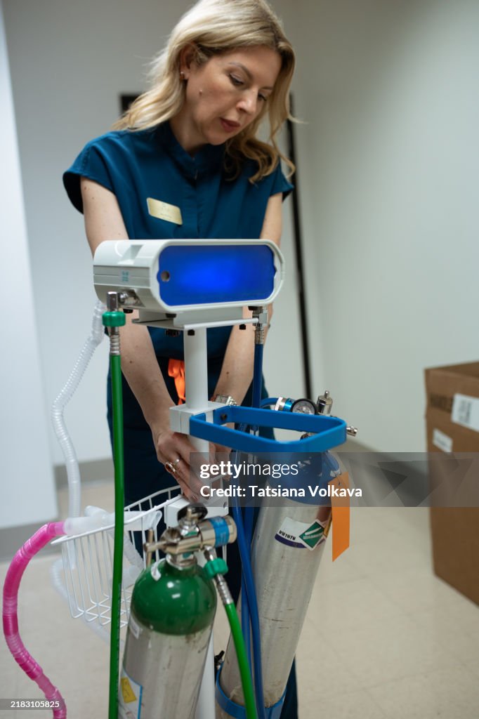 Medical professional adjusting a portable pain relief system delivering comfort with oxygen and nitrous oxide.